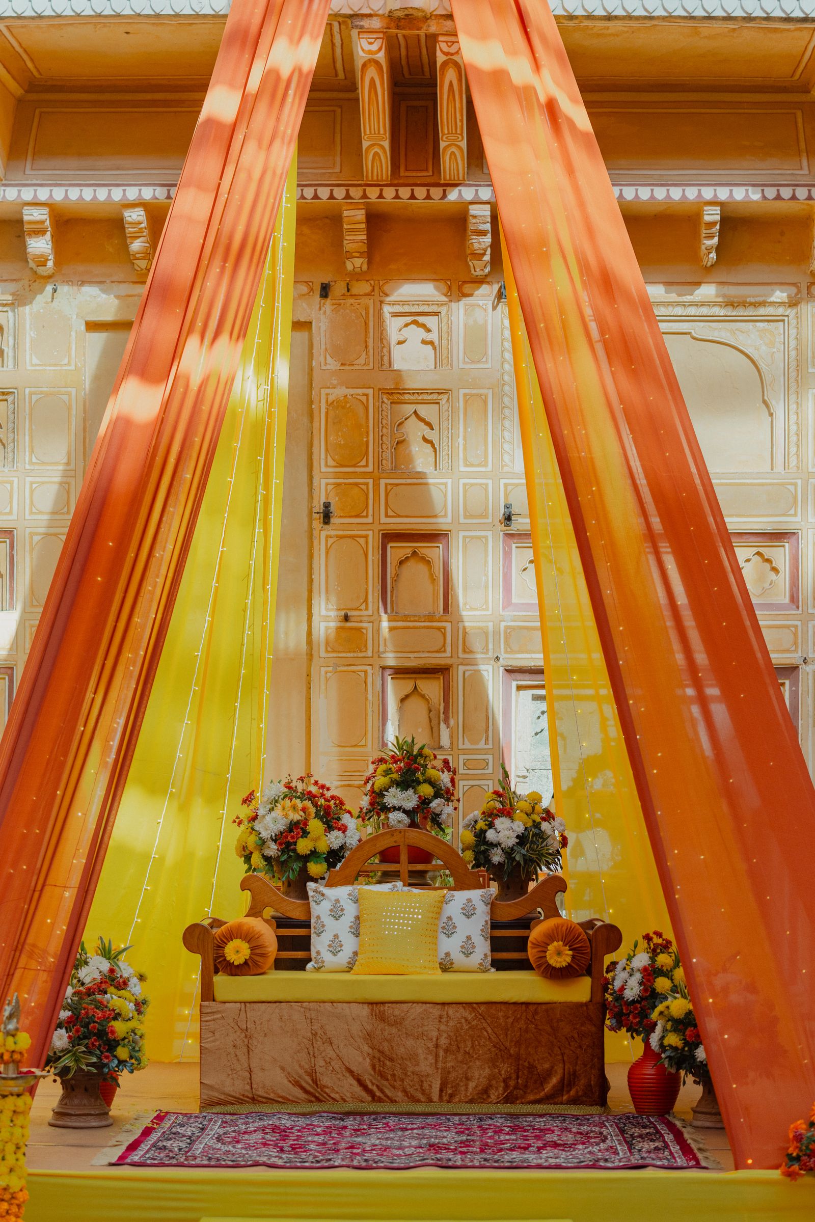 Vibrant Indian wedding stage with floral drapes